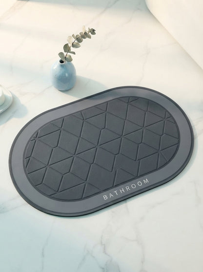 A premium, textured silicone door mat displayed on a white marble floor with a small blue accent vase in a minimalist entrywa